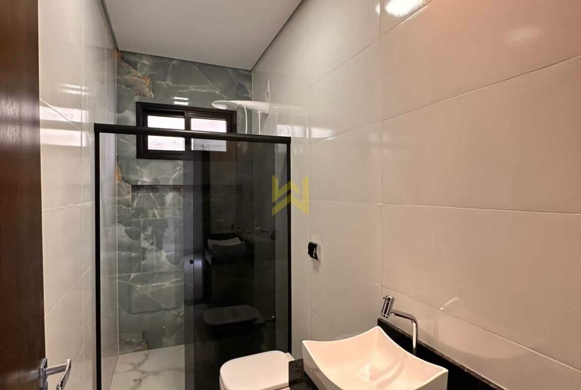 Banheiro moderno em imóvel à venda em Vilhena - RO, com revestimento marmorizado e bancada em granito — Wender Imóveis.