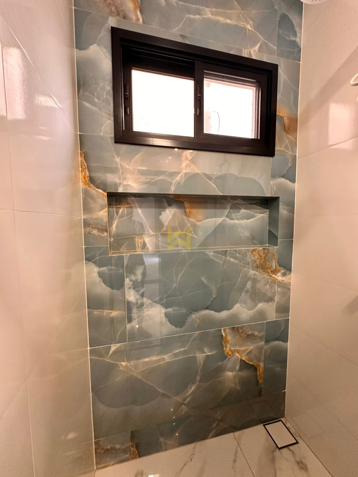 Banheiro moderno em Vilhena – Wender Imóveis Banheiro moderno em imóvel à venda em Vilhena - RO, com revestimento marmorizado e bancada em granito — Wender Imóveis.