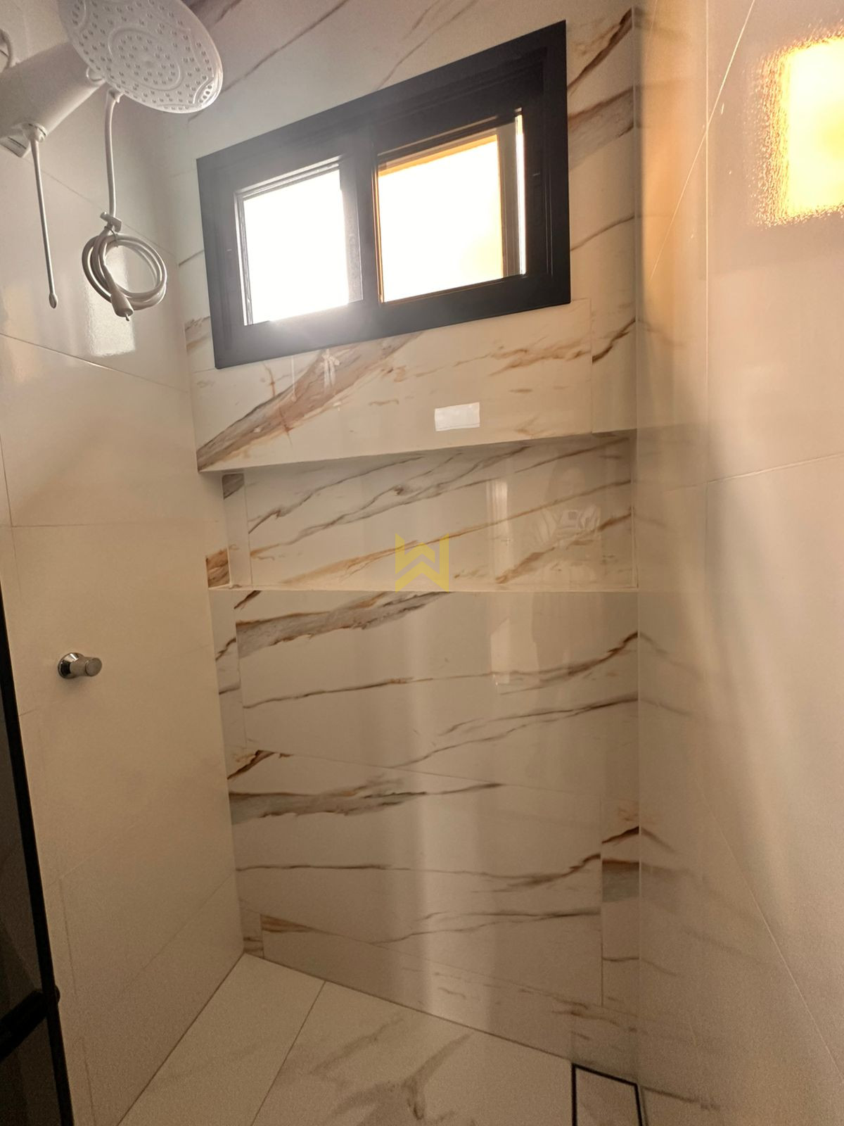 Banheiro moderno em Vilhena – Wender Imóveis Banheiro moderno em imóvel à venda em Vilhena - RO, com revestimento marmorizado e bancada em granito — Wender Imóveis.